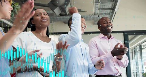 Celebrating business team applauding with digital data charts overlay showing growth