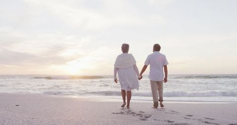 Senior Couple Walking Hand in Hand on Tranquil Beach at Sunset - Download Free Stock Images Pikwizard.com