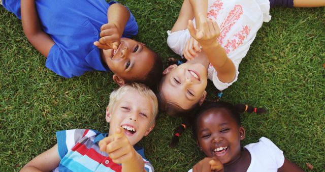 Happy Children Lying on Grass Pointing Upwards - Download Free Stock Images Pikwizard.com