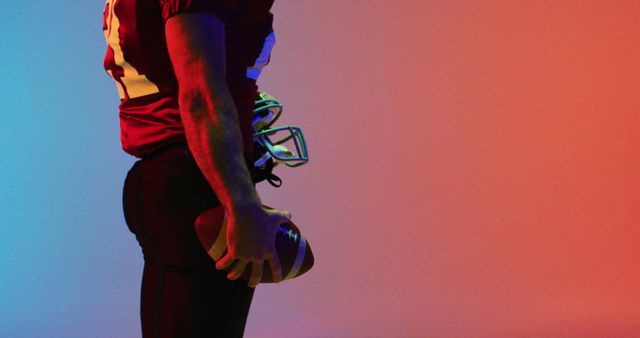 Football Player Holding Ball Under Colorful Lighting - Download Free Stock Images Pikwizard.com