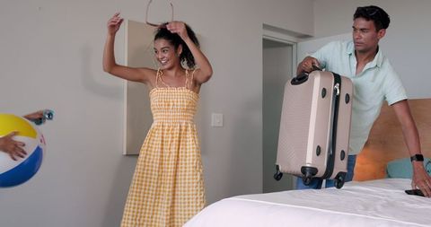 Couple ready for beach vacation in hotel room