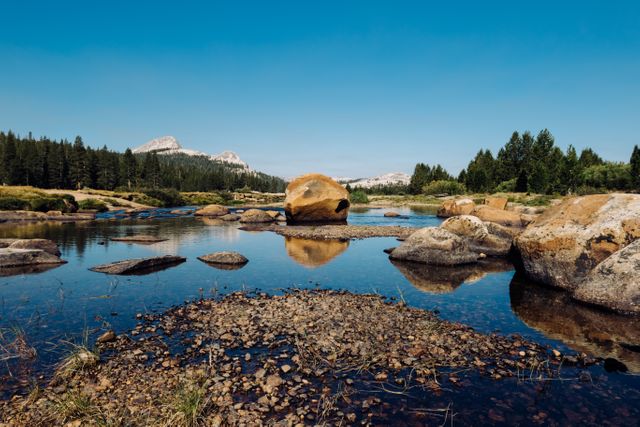 Scenic Mountain Lake with Clear Water and Rocks under Blue Sky - Download Free Stock Photos Pikwizard.com