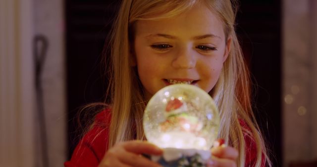 Young Girl Fascinated by Sparkling Snow Globe Indoors - Download Free Stock Images Pikwizard.com