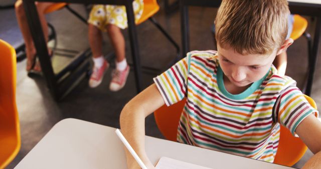 Elementary School Boy Concentrating on Writing at Desk - Download Free Stock Images Pikwizard.com