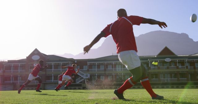 Rear view of African american rugby player kicking the ball from the kicking tee in the stadium. He is kicking penalty 4k