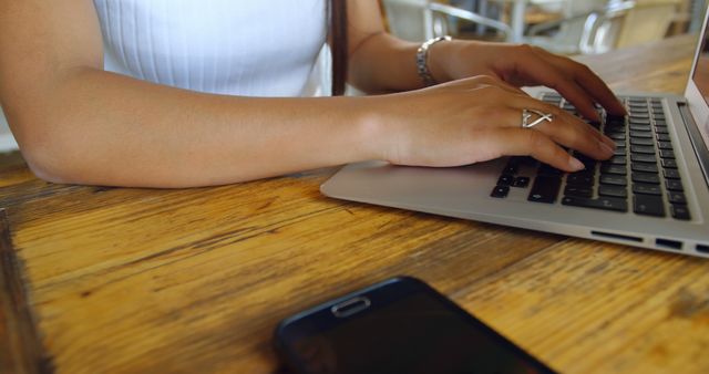 Close-up of Woman Typing on Laptop at Wooden Table - Download Free Stock Images Pikwizard.com