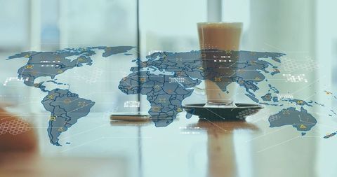 Latte on Glossy Desk with Digital World Map Overlay for Global Business and Remote Work