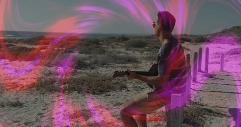 Bohemian guitarist in harmonious coastal landscape