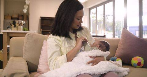 Mother Bottle-Feeding Infant in Sunlit Living Room