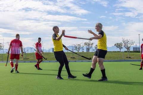 Field hockey players celebrating on turf