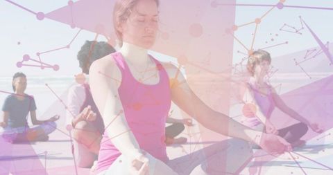 Meditating woman in pink tank leading outdoor group yoga on sunlit beach with network overlay