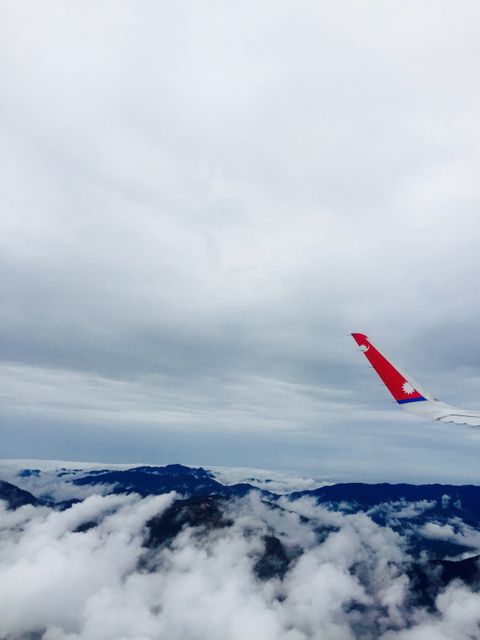 This image shows an airplane wing flying over beautiful mountains and clouds. It is perfect for illustrating traveling, aviation, and scenic views. It can be used in travel blogs, aviation-related content, tourism advertisements, and promotional materials for airlines.