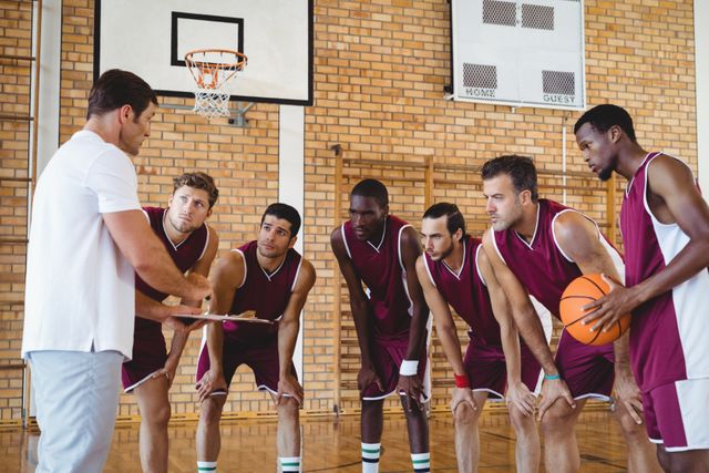 Coach Explaining Game Plan to Basketball Team in Gym - Download Free Stock Photos Pikwizard.com