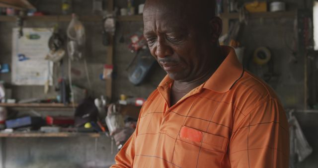 Mechanic Working in Garage, Wearing an Orange Polo - Download Free Stock Images Pikwizard.com