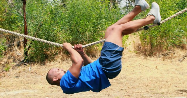 A young Caucasian boy is actively swinging on a rope in an outdoor setting, with copy space - Download Free Stock Photos Pikwizard.com