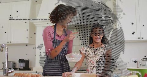 Mother and daughter baking together in bright kitchen teaching dough kneading