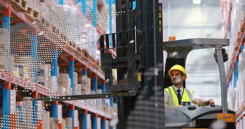 Operating forklift navigating warehouse aisles, hi-vis operator managing pallet racking