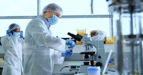 Scientists handling samples using microscope in modern bioscience laboratory
