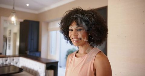 Smiling woman standing in bright modern kitchen with dotted world map overlay