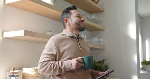 Middle-Aged Man Enjoying Morning Drink in Cozy Kitchen