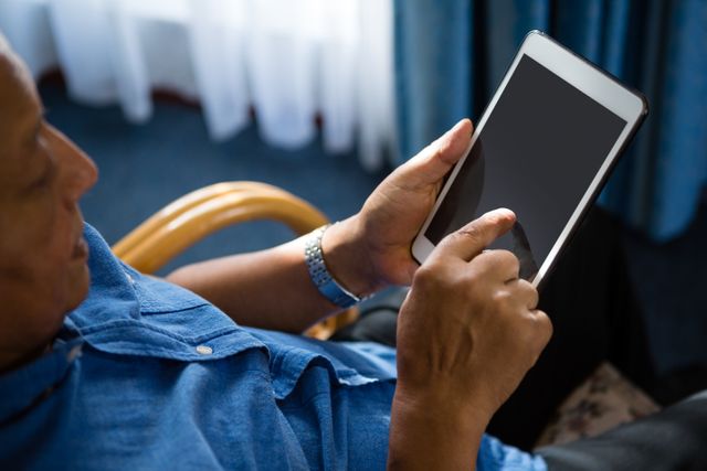 High angle view of senior man using digital tablet at nursing home