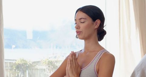 Woman Practicing Mindfulness Meditation by Bright Window
