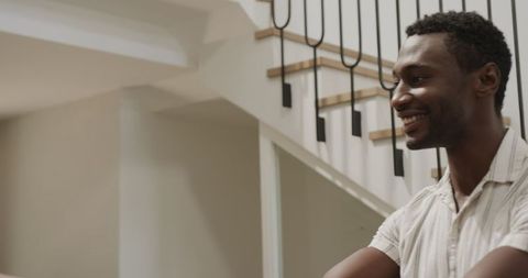 Smiling man engaged in conversation near modern staircase
