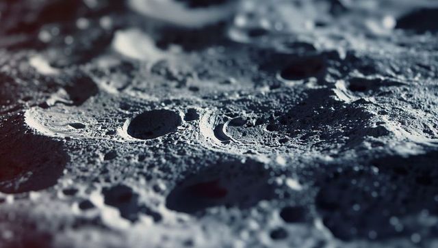 Lunar surface with craters and dust under low-angle light