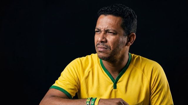 Leaning man wearing yellow green jersey looking concerned and reflective studio portrait