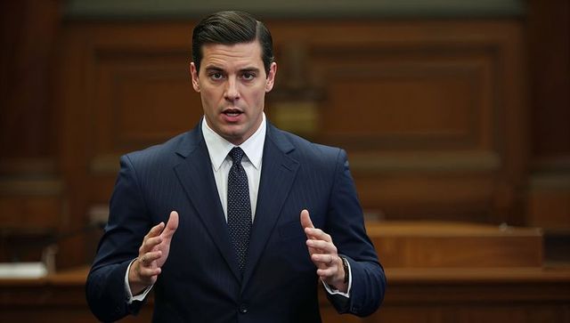 Confident attorney delivering courtroom argument in navy pinstripe suit, gesturing at hearing
