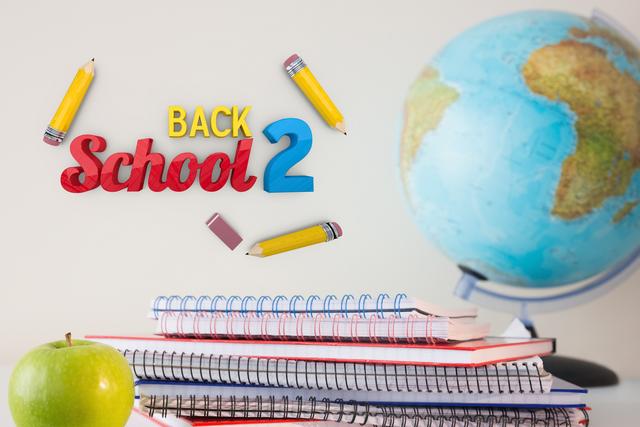 composite of back to school text with notebooks globe and apple