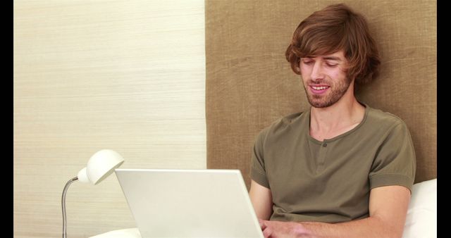 Young Man Using Laptop Computer Sitting on Bed - Download Free Stock Images Pikwizard.com