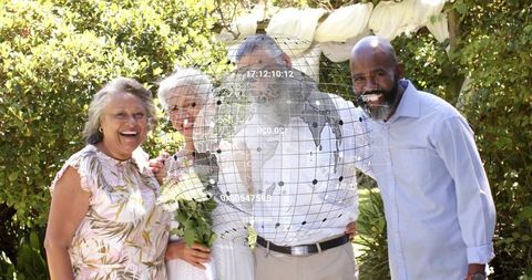 Smiling multigenerational group celebrating backyard wedding with digital globe overlay