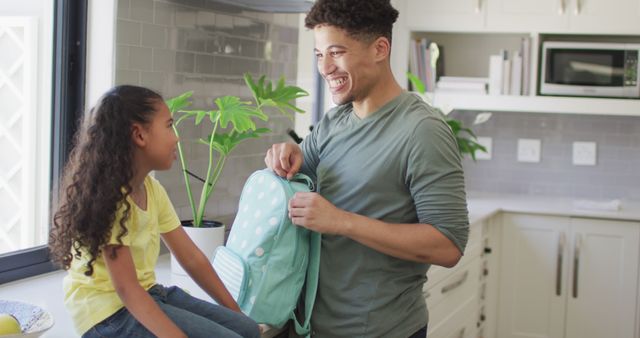 Happy biracial father and daughter packing lunch for school - Download Free Stock Photos Pikwizard.com
