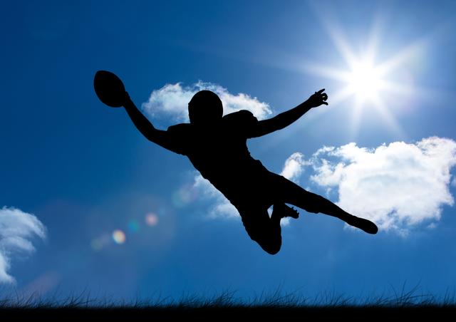 Silhouette of a rugby player leaping to catch the ball against a bright sky with the sun shining and clouds in the background. Ideal for use in sports promotions, athletic event advertisements, motivational posters, and dynamic action-themed designs.