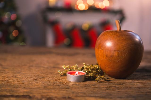 Wooden apple with tealight candle on wooden table during christmas time