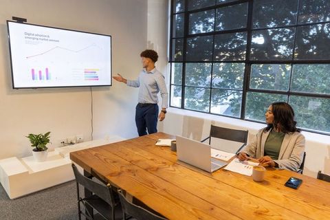 African american professionals presenting digital adoption charts in modern office meeting