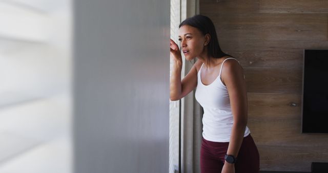 Woman Looking Out Window with Curious Expression at Home - Download Free Stock Images Pikwizard.com