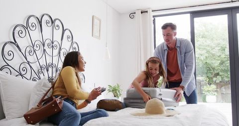 Family Packing for Vacation in Bedroom