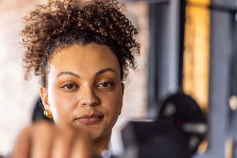 African american woman lifting dumbbell and focusing on strength and determination