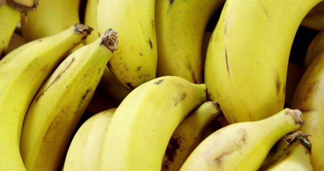 A close-up view of ripe bananas clustered together, showcasing their vibrant yellow color and natural spots. Bananas are a popular fruit known for their nutritional benefits and versatility in various dishes.