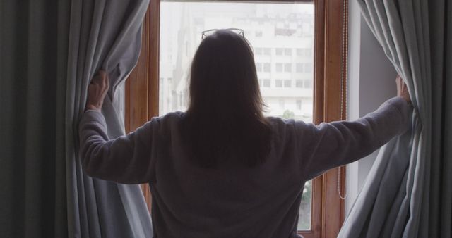 Woman Opening Curtains to Morning Light in City Apartment - Download Free Stock Images Pikwizard.com