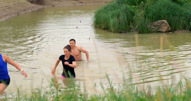 Participants Running Through Muddy Water at Outdoor Obstacle Race - Download Free Stock Images Pikwizard.com