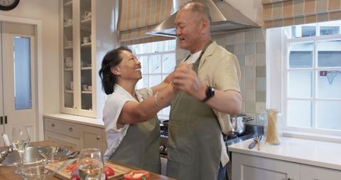 Senior Couple Dancing Joyfully in a Cozy Kitchen