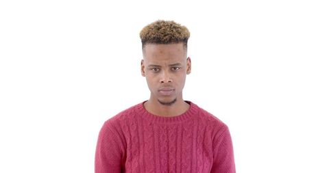 Serious man in red sweater posing against white background