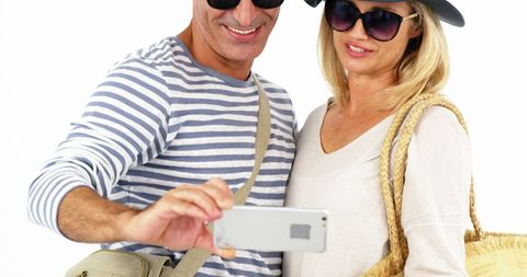 Happy Couple Taking Selfie in Casual Outfits Against White Background