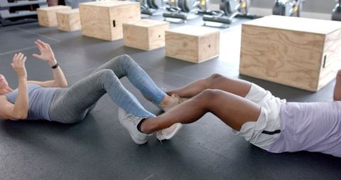 Diverse Couple Performing Partner Sit-Ups at Gym for Fitness - Download Free Stock Images Pikwizard.com