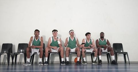 Diverse Basketball Team Players Discussing Strategy in Gym