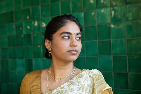 Elegant indian woman in traditional sari with gold jewelry
