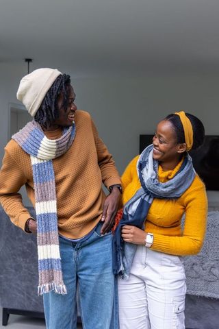 African american couple sharing cozy laughs in mustard sweaters and knit scarves